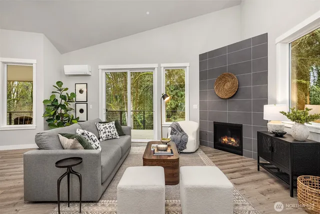 a living room with furniture a fireplace and a large window