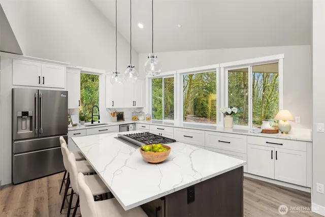a kitchen with stainless steel appliances a table chairs and a refrigerator