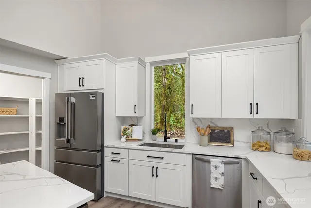 a kitchen with stainless steel appliances a refrigerator sink and cabinets