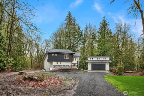 a front view of a house with a garden and tree