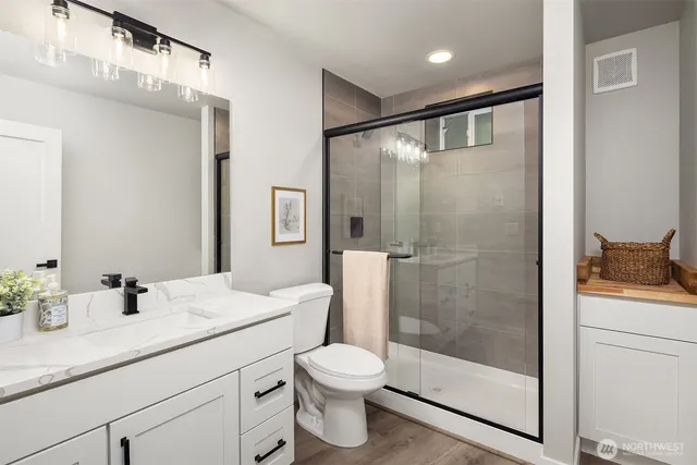 a bathroom with a shower sink vanity mirror and toilet