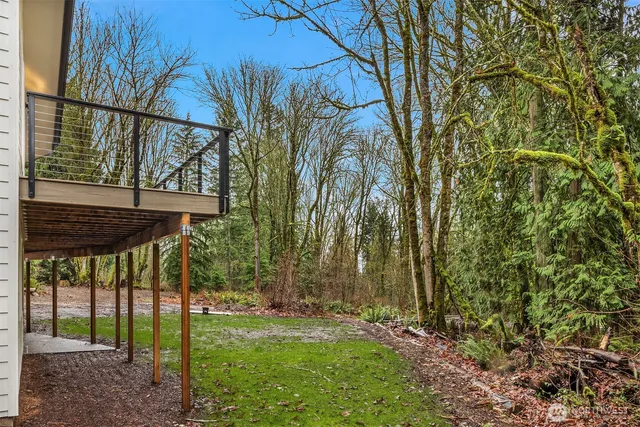 a view of a backyard with table and chairs under an umbrella
