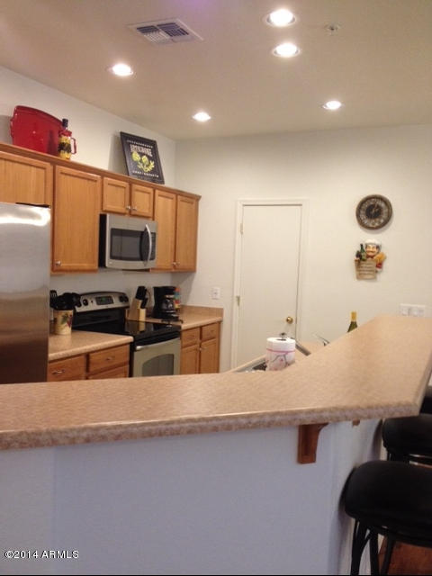 1250 South Rialto, Unit 62 Mesa, AZ 85209 - Photo 11 of 24 a kitchen with stainless steel appliances kitchen island granite countertop a sink and a stove