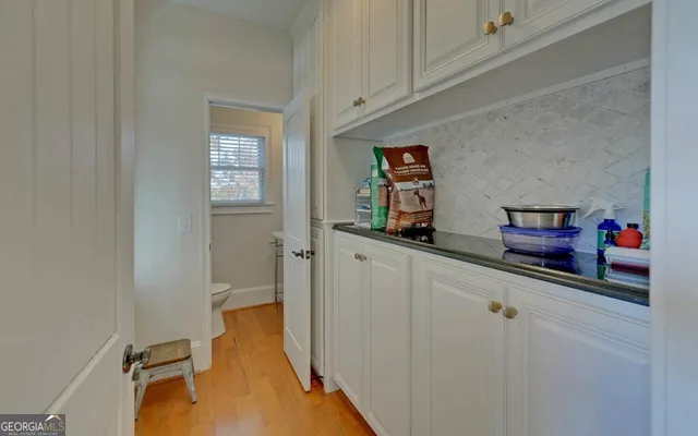 a view of a hallway with wooden floor and staircase