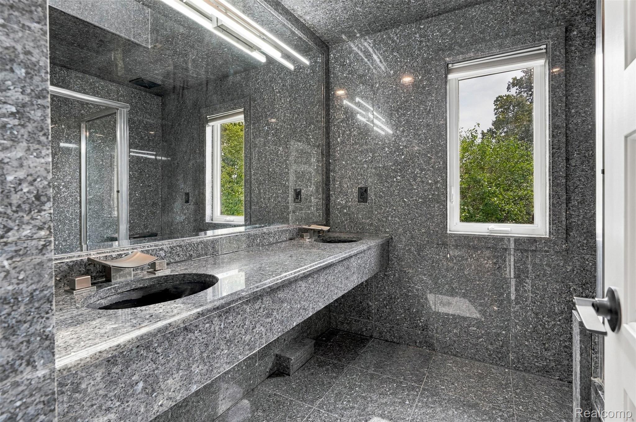 27507 Bell Road Southfield, MI 48034 - Photo 24 of 81 Bathroom featuring full-height stone slab walls, stone flooring, a stone floating vanity with an integrated basin, and a framed window