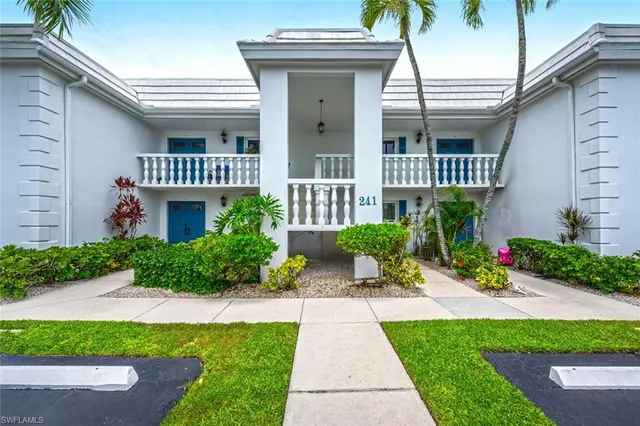 a front view of a house with a yard and potted plants