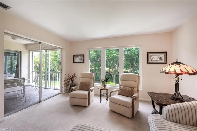 a living room with furniture and a floor to ceiling window