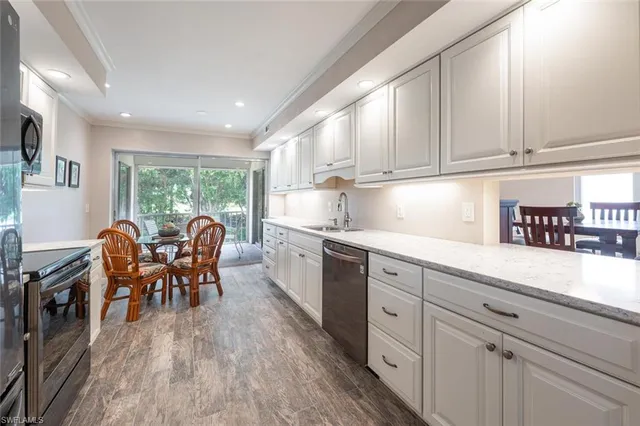a kitchen with granite countertop cabinets stainless steel appliances with chair and table