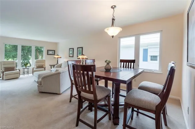 a dining room with furniture a chandelier and window