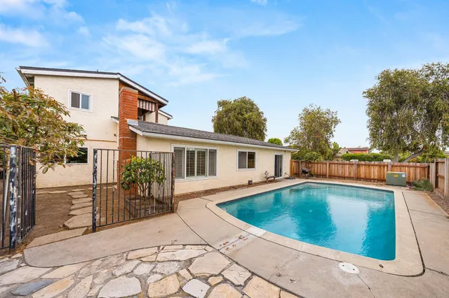 a view of a house with backyard and sitting area