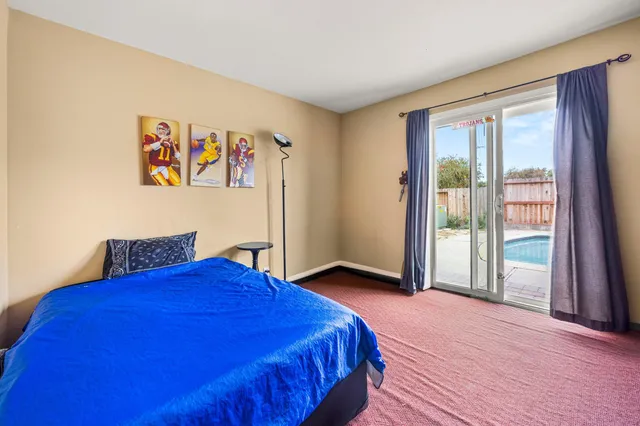 a bedroom with a bed and a large window