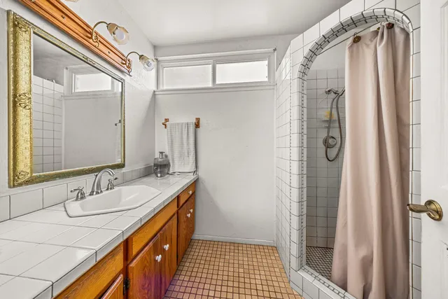 a bathroom with a double vanity sink a mirror and shower