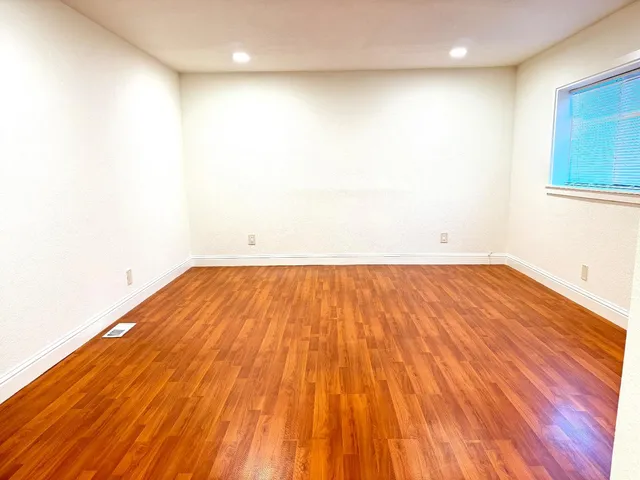 a view of a room with wooden floor and a sink