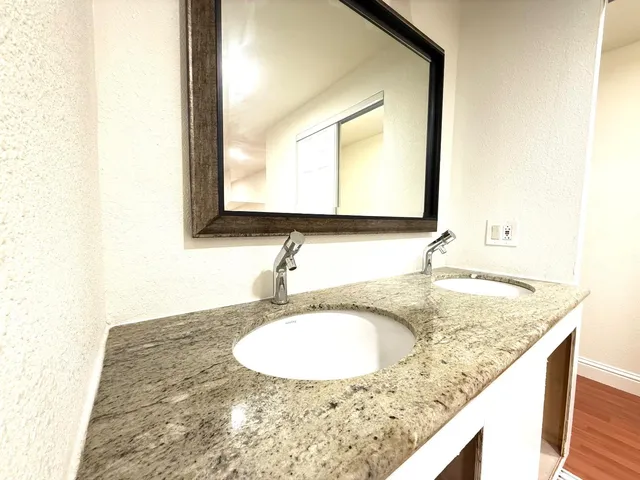 a bathroom with a granite countertop sink and a mirror