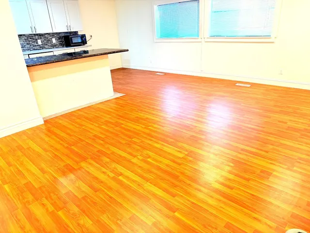 a view of a kitchen with stainless steel appliances a sink and a stove