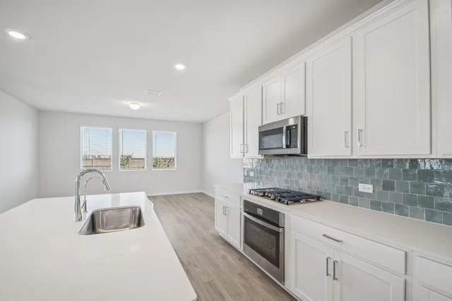 a kitchen with granite countertop white cabinets and white appliances