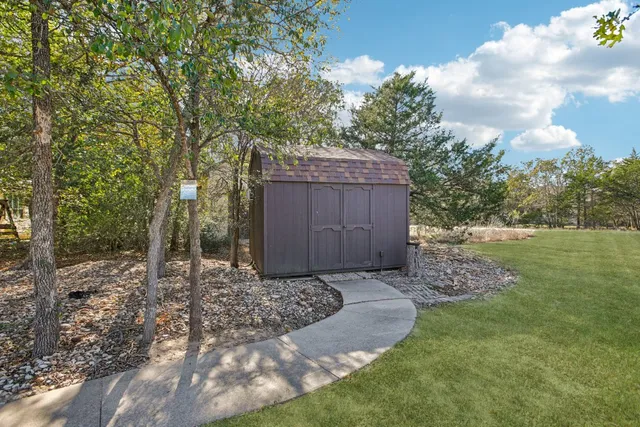 a view of a hallway with wooden floor and chandelier