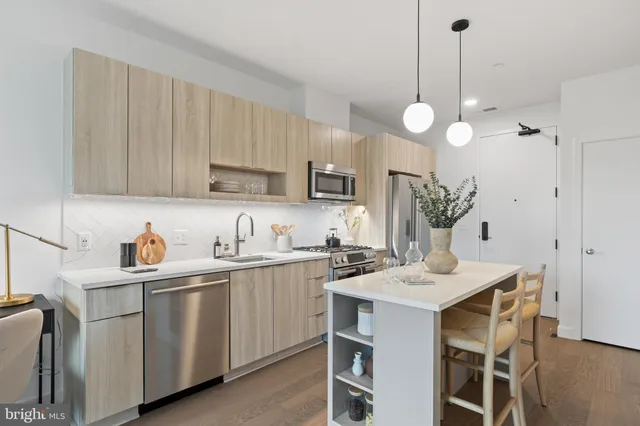 a kitchen with cabinets a center island and appliances