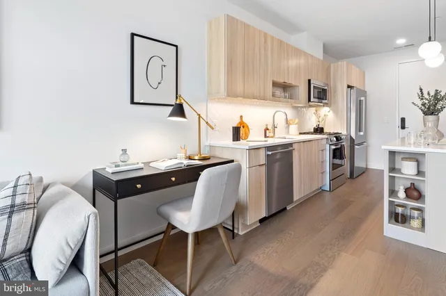 a kitchen with kitchen island granite countertop a sink cabinets and stainless steel appliances