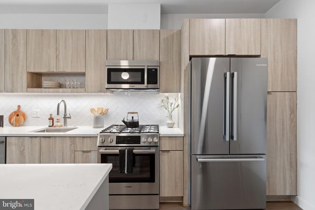 a kitchen with stainless steel appliances and refrigerator