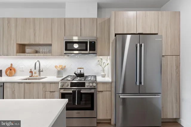 a kitchen with stainless steel appliances and refrigerator