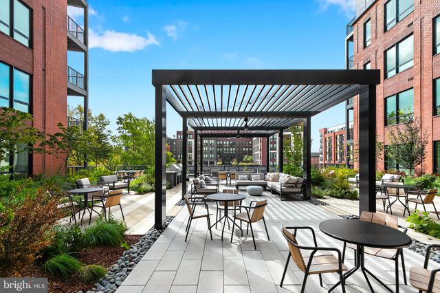 a view of a patio with table and chairs potted plants and floor to ceiling window