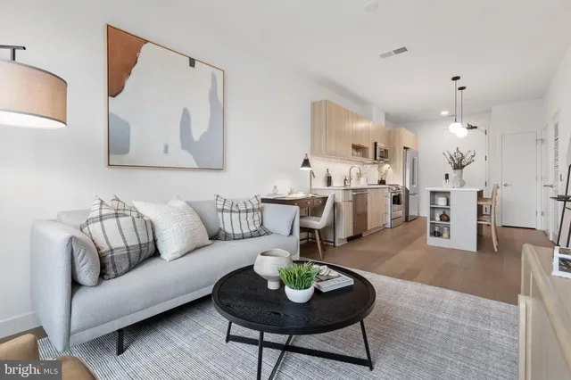 a living room with furniture and a dining table with kitchen view