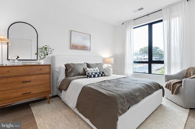 a bedroom with a bed and a large window