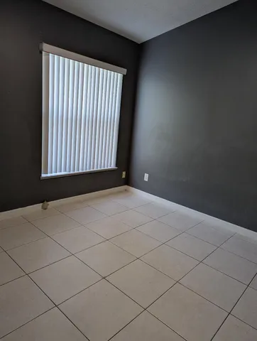 a view of a livingroom with an empty space and a window