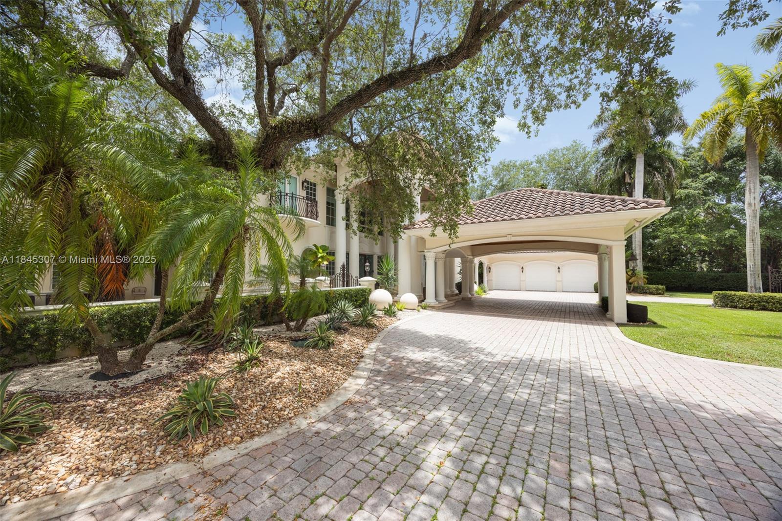 0 7245 Southwest 104th Street Pinecrest, FL 33156 - Photo 14 of 74 a front view of a house with a yard and garage