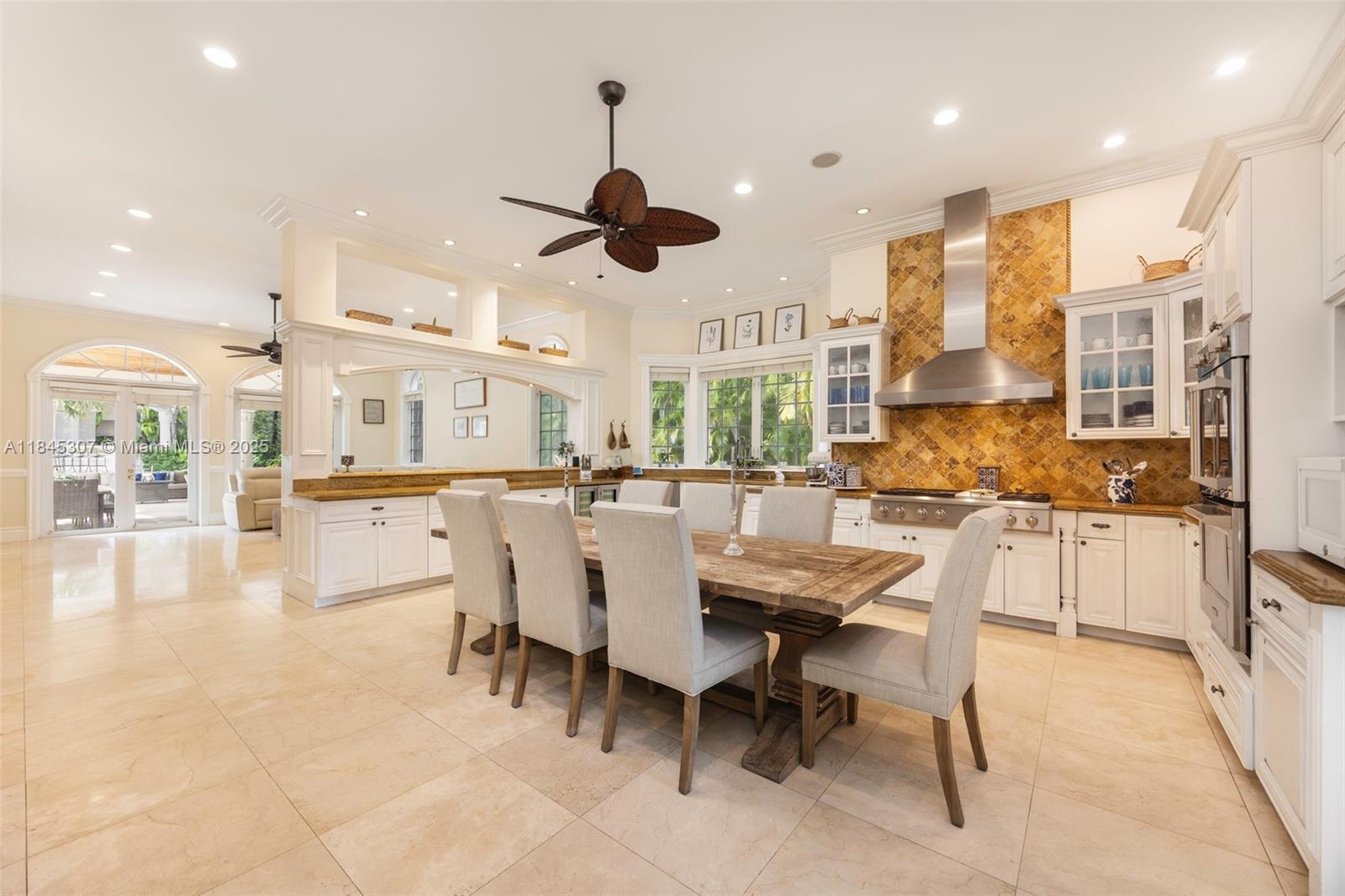 0 7245 Southwest 104th Street Pinecrest, FL 33156 - Photo 32 of 74 a dining room with stainless steel appliances kitchen island granite countertop a table and chairs