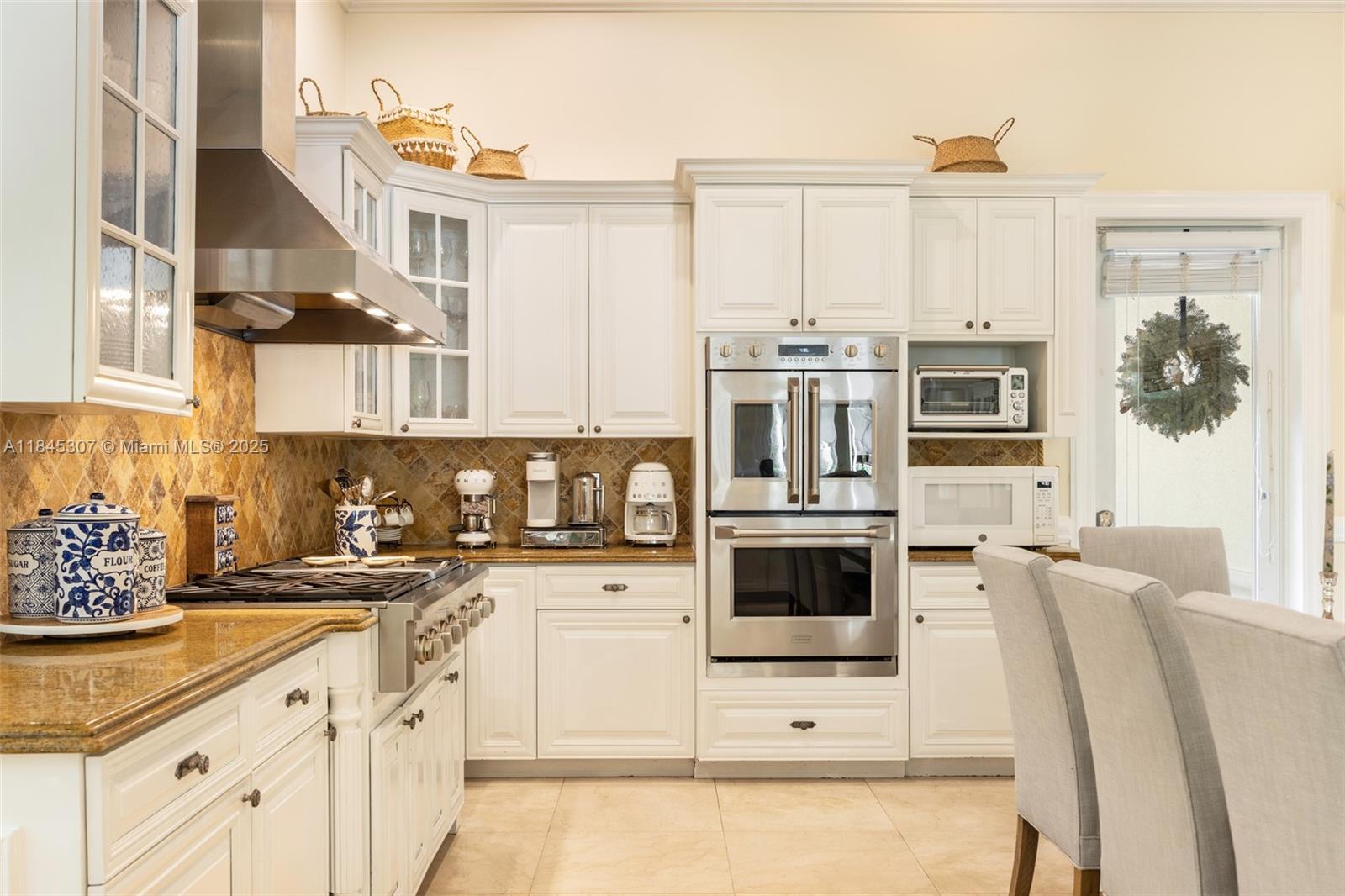 0 7245 Southwest 104th Street Pinecrest, FL 33156 - Photo 35 of 74 a kitchen with stainless steel appliances white cabinets and wooden floor