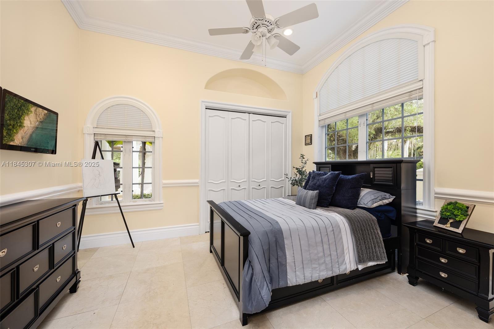 0 7245 Southwest 104th Street Pinecrest, FL 33156 - Photo 37 of 74 a bedroom with a bed and a chandelier