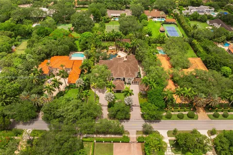 an aerial view of a house with a yard and swimming pool