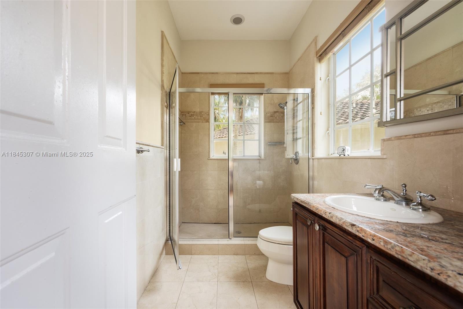 0 7245 Southwest 104th Street Pinecrest, FL 33156 - Photo 57 of 74 a bathroom with a granite countertop sink toilet and shower