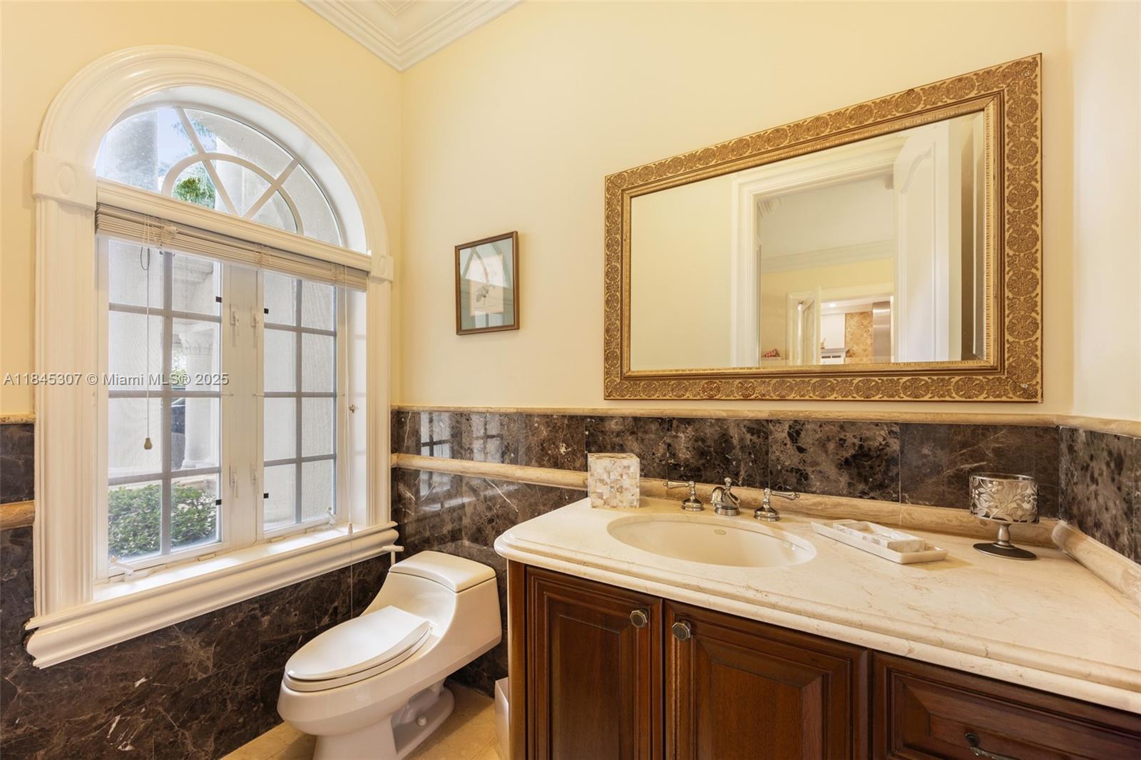 0 7245 Southwest 104th Street Pinecrest, FL 33156 - Photo 58 of 74 a bathroom with a sink a toilet a large mirror and a window