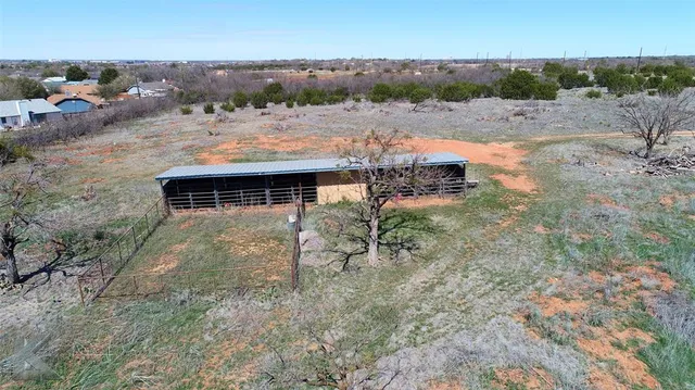 an aerial view of a house with a yard and lake view
