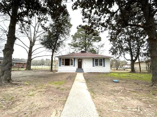 a front view of a house with a yard and trees