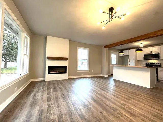 a view of a room with kitchen appliances and wooden floor