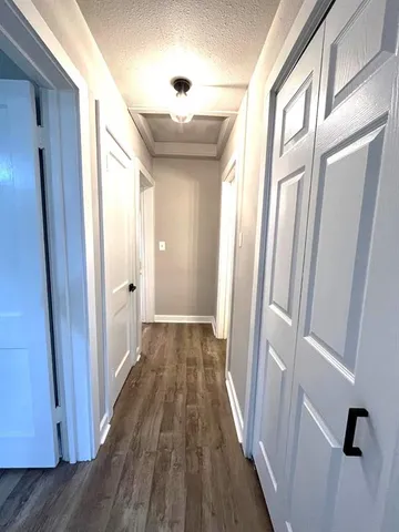 a view of a hallway with wooden floor and staircase