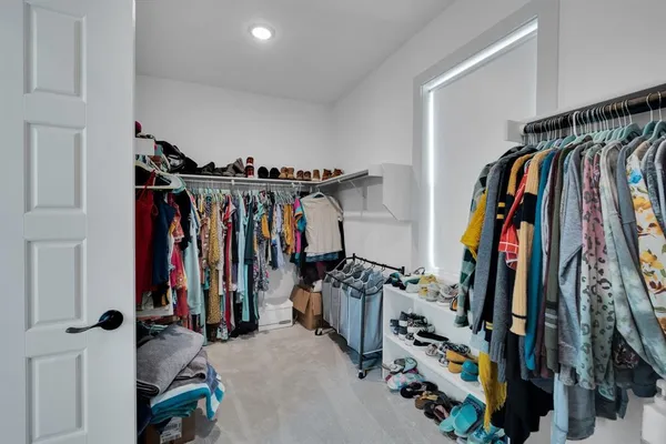 a view of walk in closet with clothes