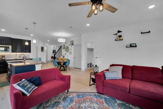 a living room with furniture kitchen view and a chandelier