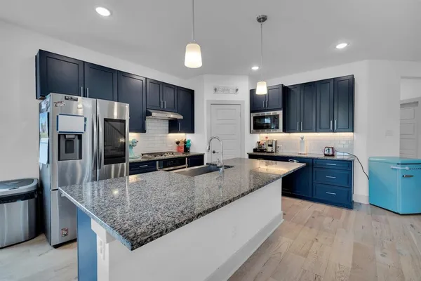 a kitchen with stainless steel appliances granite countertop a sink refrigerator and microwave