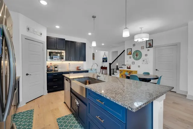 a kitchen with stainless steel appliances granite countertop a sink a stove and a refrigerator