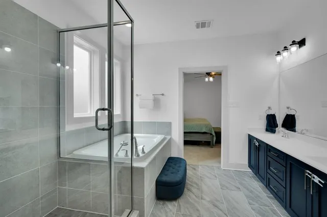 a en suite bathroom with a tub shower and a sink