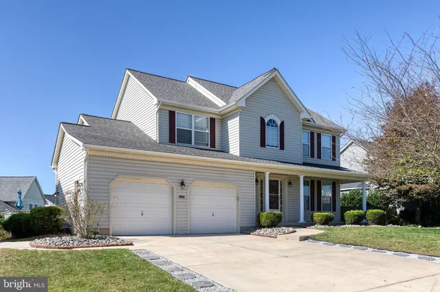 a front view of a house with a yard and potted plants