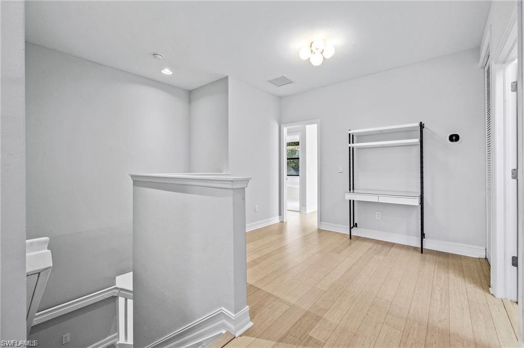 7841 Bristol Circle Naples, FL 34120 - Photo 14 of 31 Hall with an upstairs landing, light wood-style floors, and recessed lighting