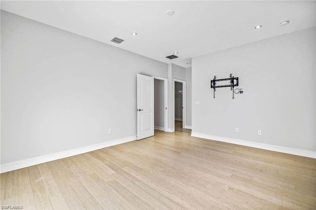7841 Bristol Circle Naples, FL 34120 - Photo 15 of 31 Spare room featuring light wood finished floors and recessed lighting