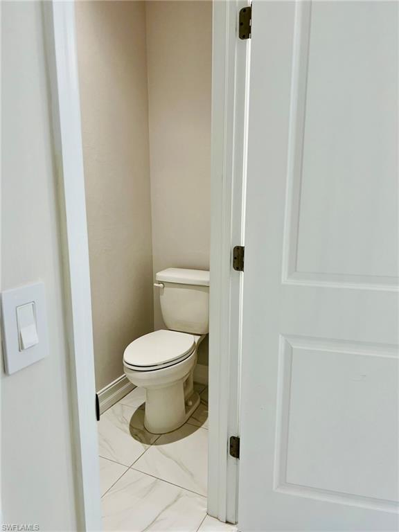 7841 Bristol Circle Naples, FL 34120 - Photo 17 of 31 Bathroom featuring toilet and baseboards