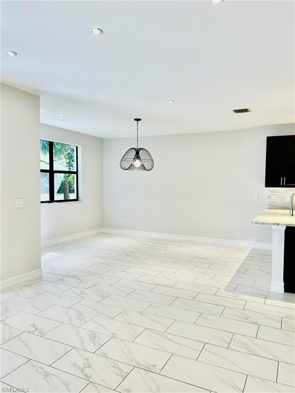 7841 Bristol Circle Naples, FL 34120 - Photo 5 of 31 Unfurnished dining area with hanging lights and light marble finish floors